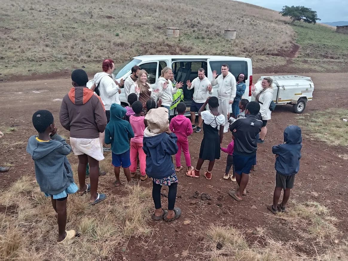 Children meeting a tour group next to a Khondlo Tours minibus